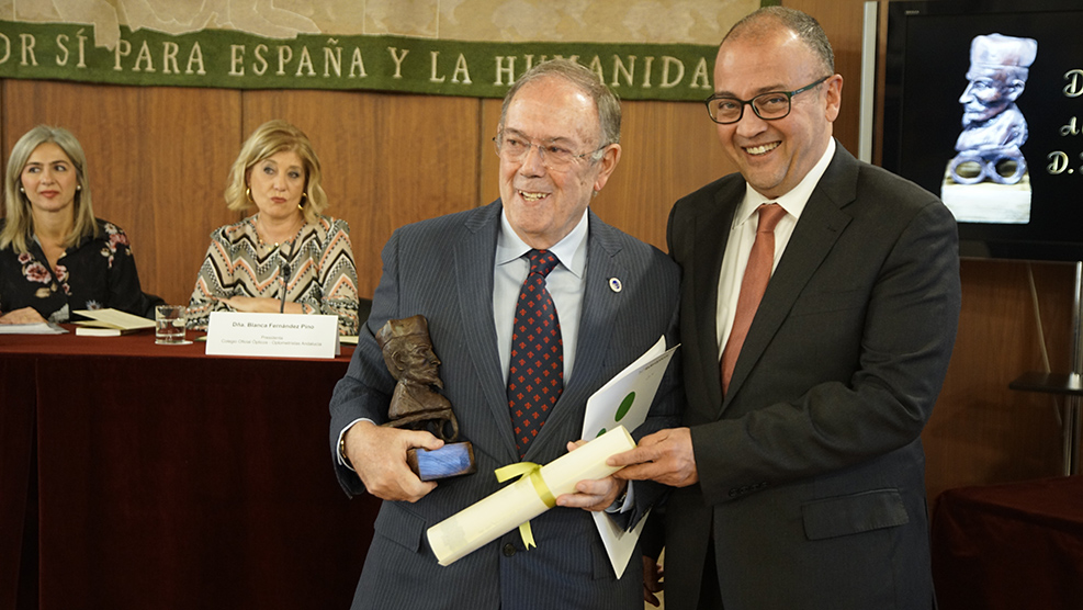 El óptico-optometrista Juan Fernández-Baca recoge su premio de la mano de Jorge Maguilla, tesorero del COOOA